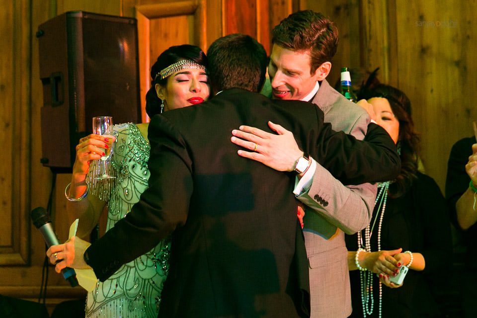 Bride and groom hugging best man