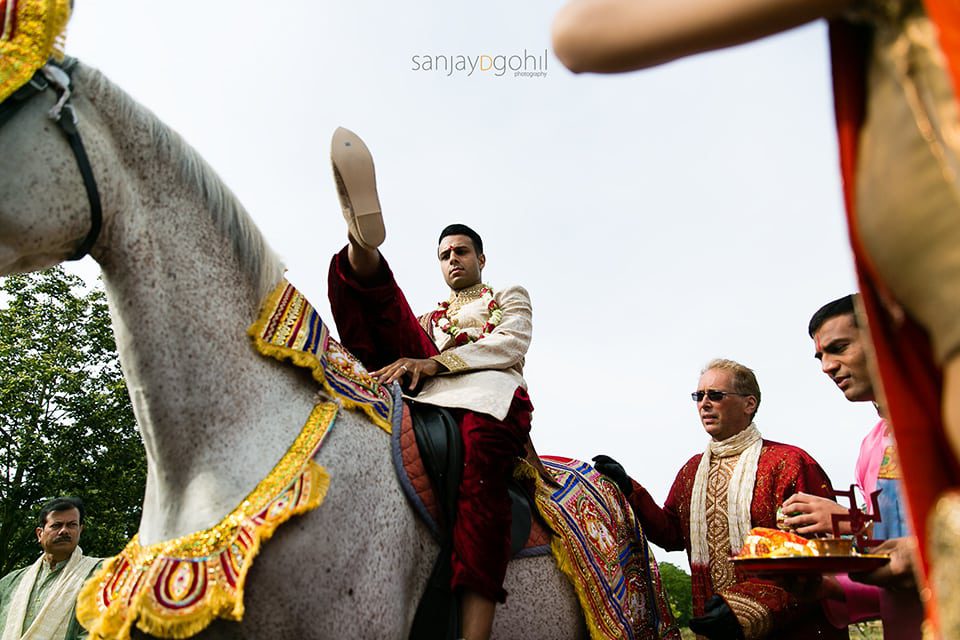 Wedding groom getting off horse