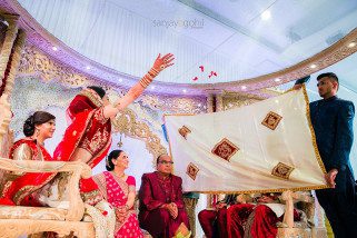 Bride throwing petals during gujarati wedding ceremony