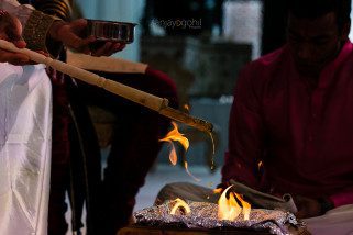 Ghee being poured into the fire during asian wedding ceremony