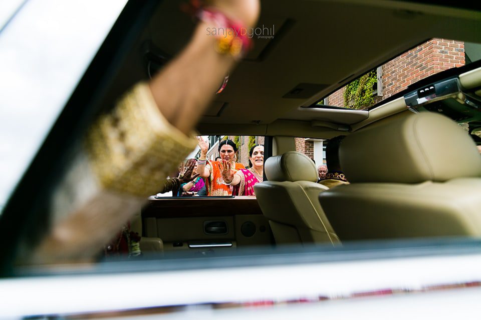 Mother of bride waving as the married couple leave