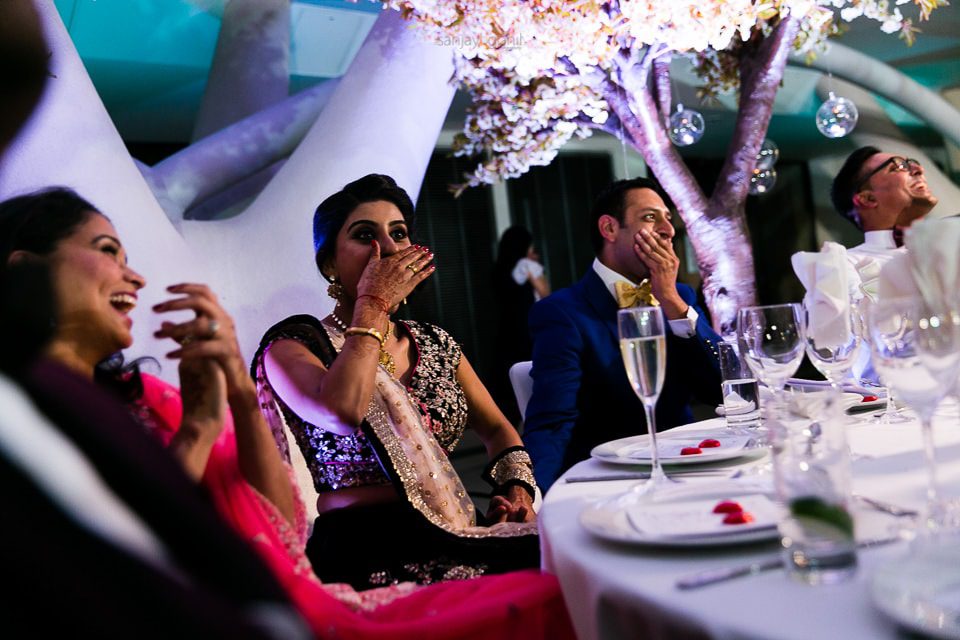 Wedding guests laughing during speechs at reception party