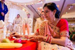 Mother of the bride lighting candle during Hindu wedding ceremony