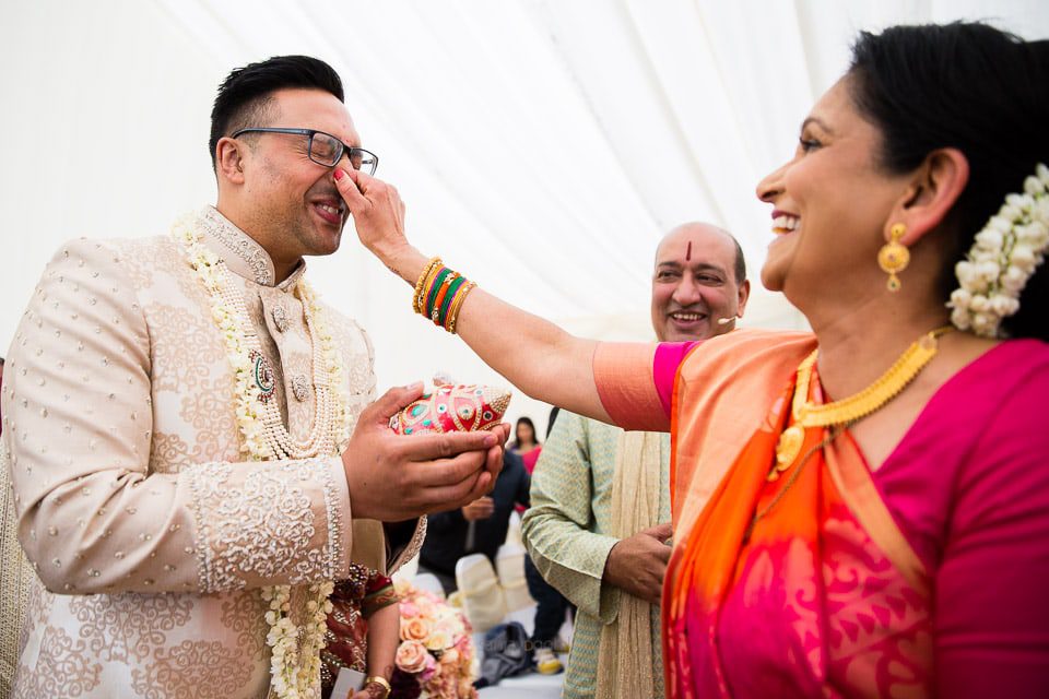 Hindu wedding groom's nose being pinched