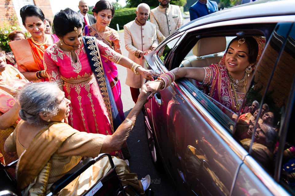 Bride holding grandmother's hand before leaving