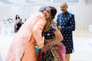 Mother of the bride hugging father of the groom