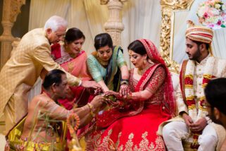 family of the bride placing auspicious items in bride's hands