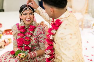 Groom placing sindoor into parting of bride's hair